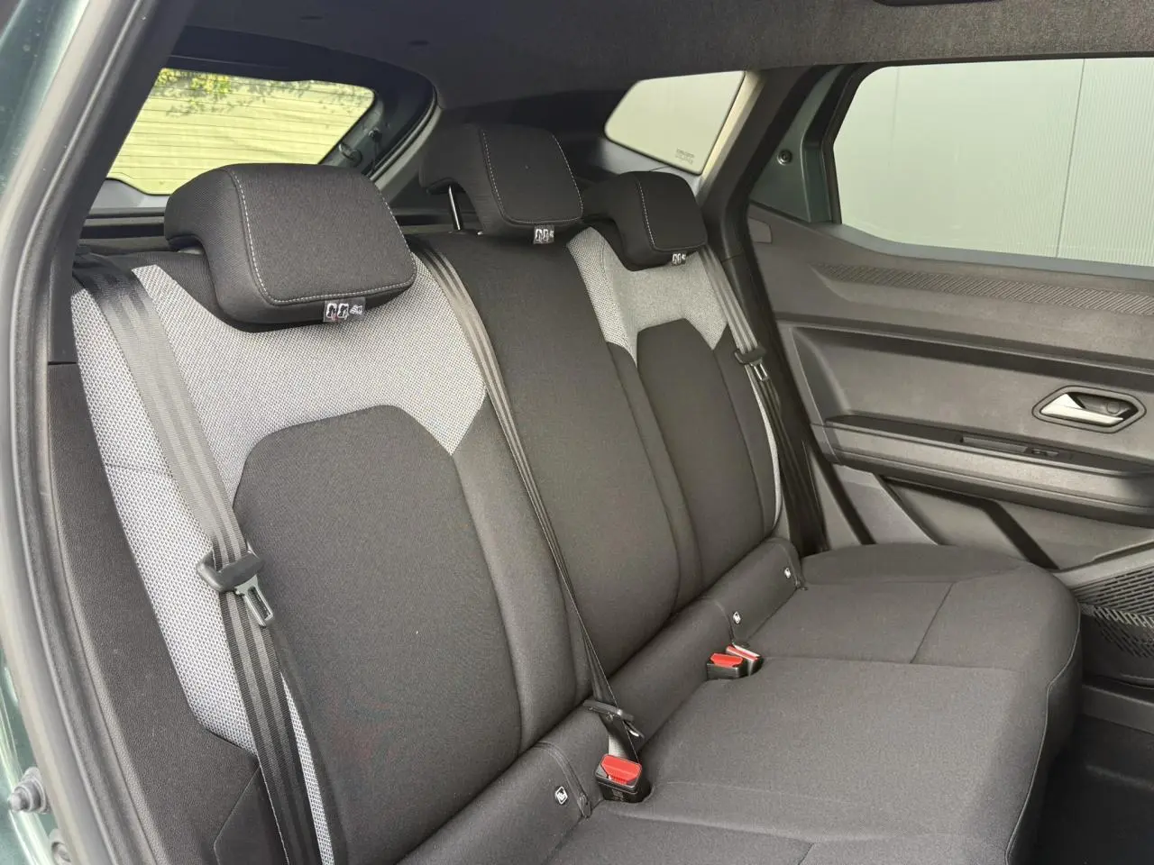 Vue intérieure côté droit sur la banquette arrière noire et grise du Dacia Duster Vert Cèdre 2026.
