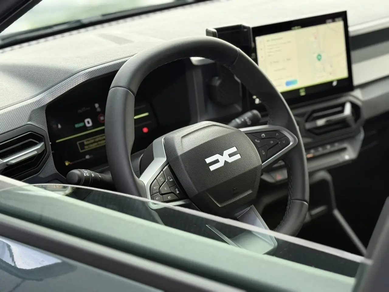 Vue rapprochée du volant et tableau de bord digital du Dacia Duster 2026, intérieur moderne et écran tactile.