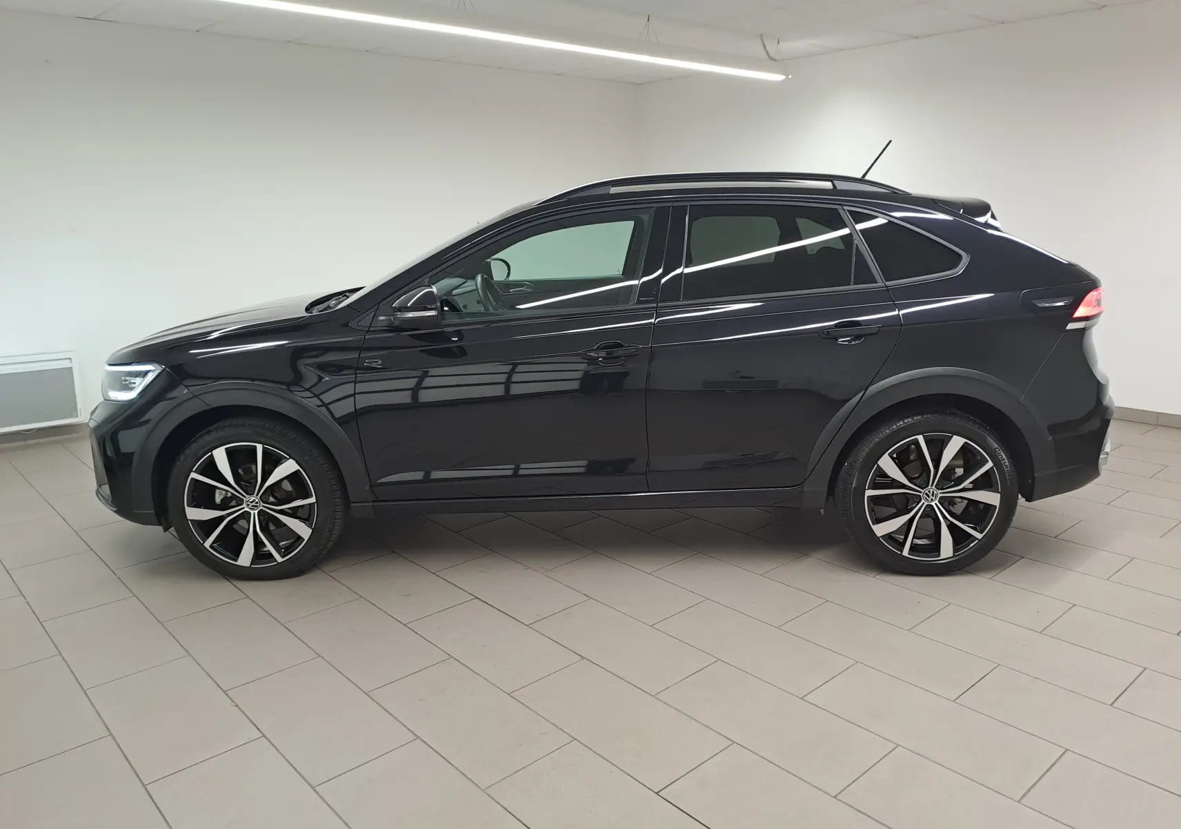 Profil côté gauche du Volkswagen Taigo noir intense 2025 avec jantes alliage 18 pouces Misano et finition R-Line Edition.