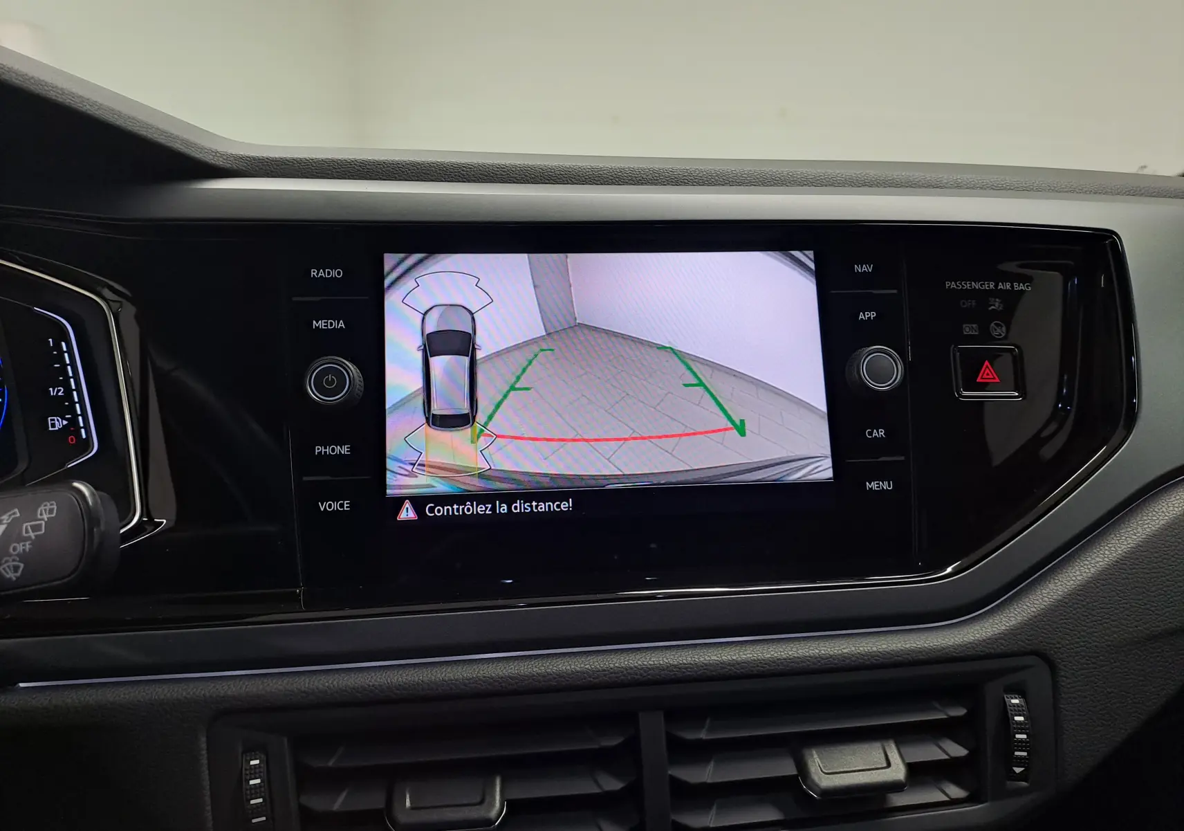 Vue intérieure du tableau de bord du Volkswagen Taigo 2025, écran central affichant la caméra de recul avec alertes de distance.
