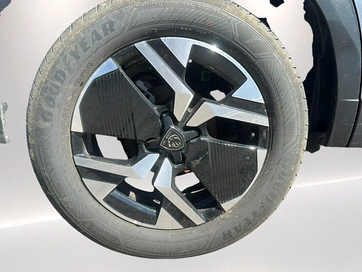 Gros plan sur la jante alu noire et argentée du côté droit d’un Peugeot 2008 gris Artense 2025.