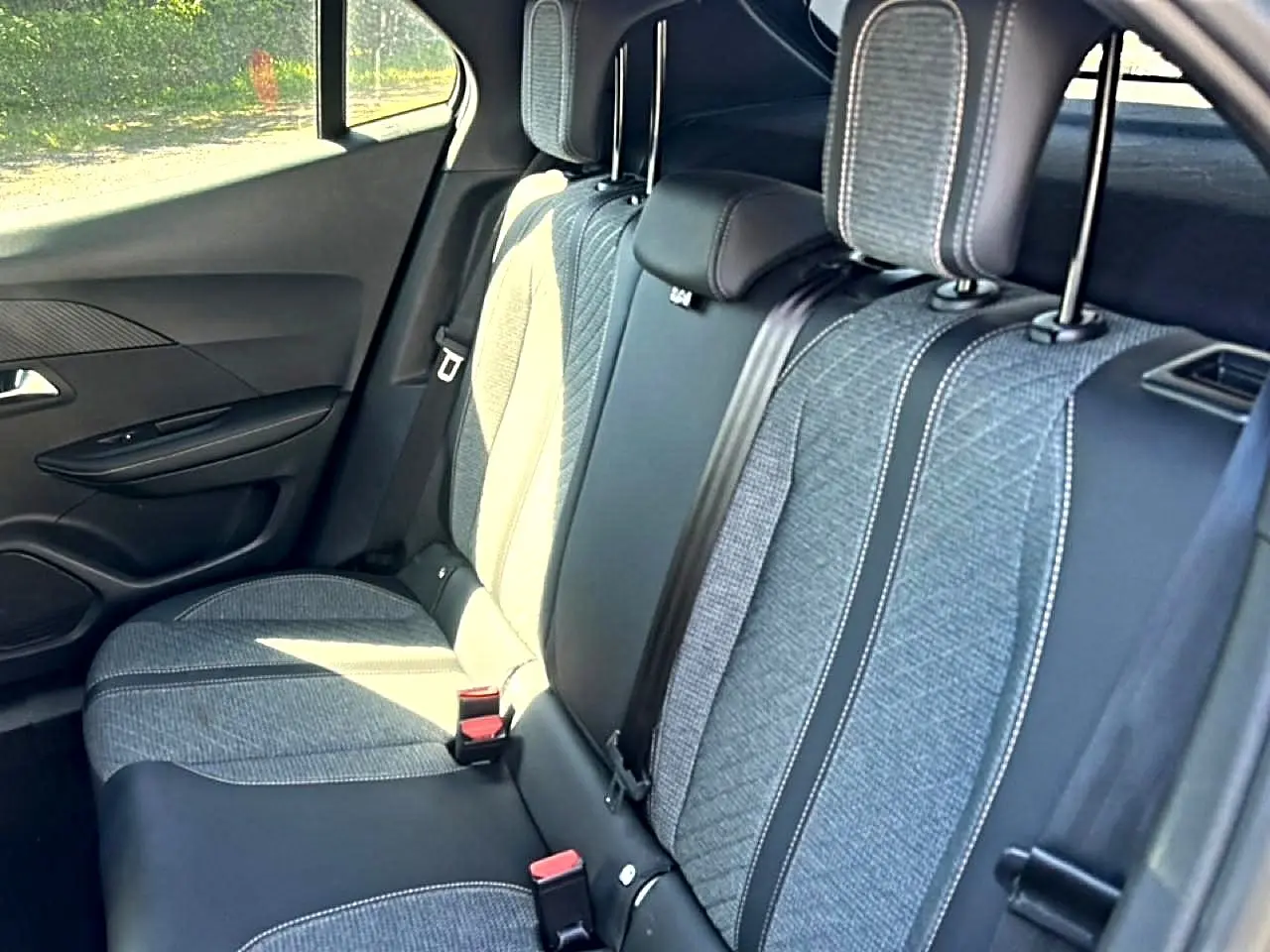 Vue intérieure côté droit sur la banquette arrière gris clair et tissu embossé du Peugeot 2008 1.2 100 allure 2025.