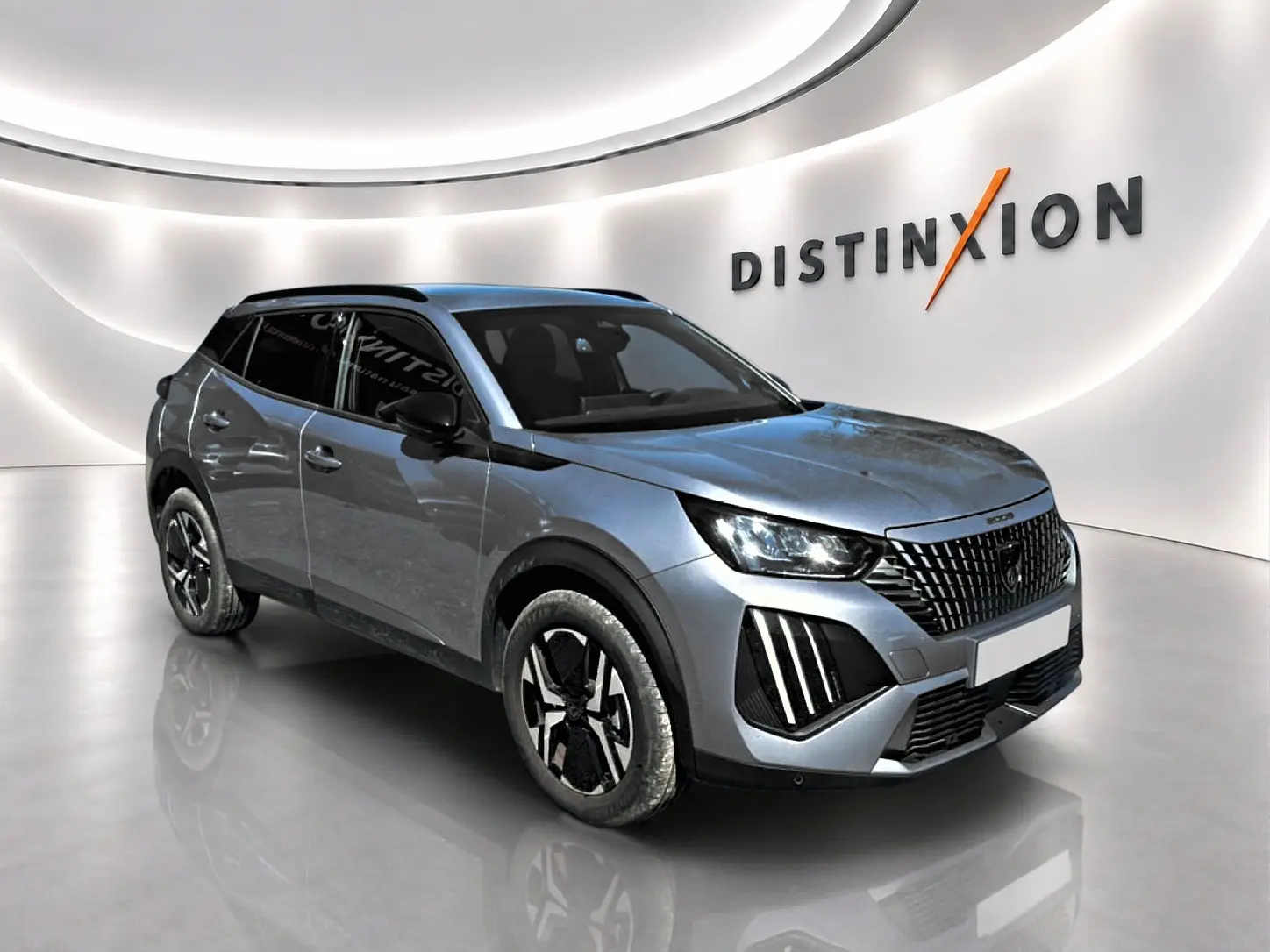 Peugeot 2008 1.2 100 Allure gris Artense en 3/4 avant droit, avec calandre distinctive et jantes alu noires.