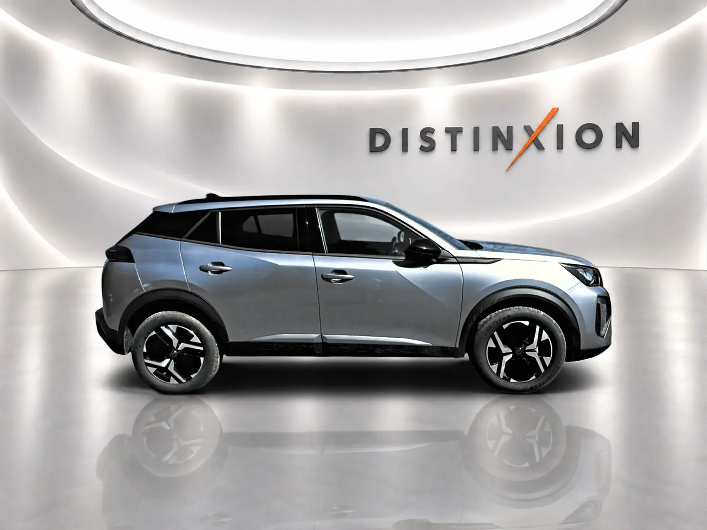 Profil droit du Peugeot 2008 1.2 100 Allure gris Artense avec jantes alu et toit noir dans un showroom lumineux.