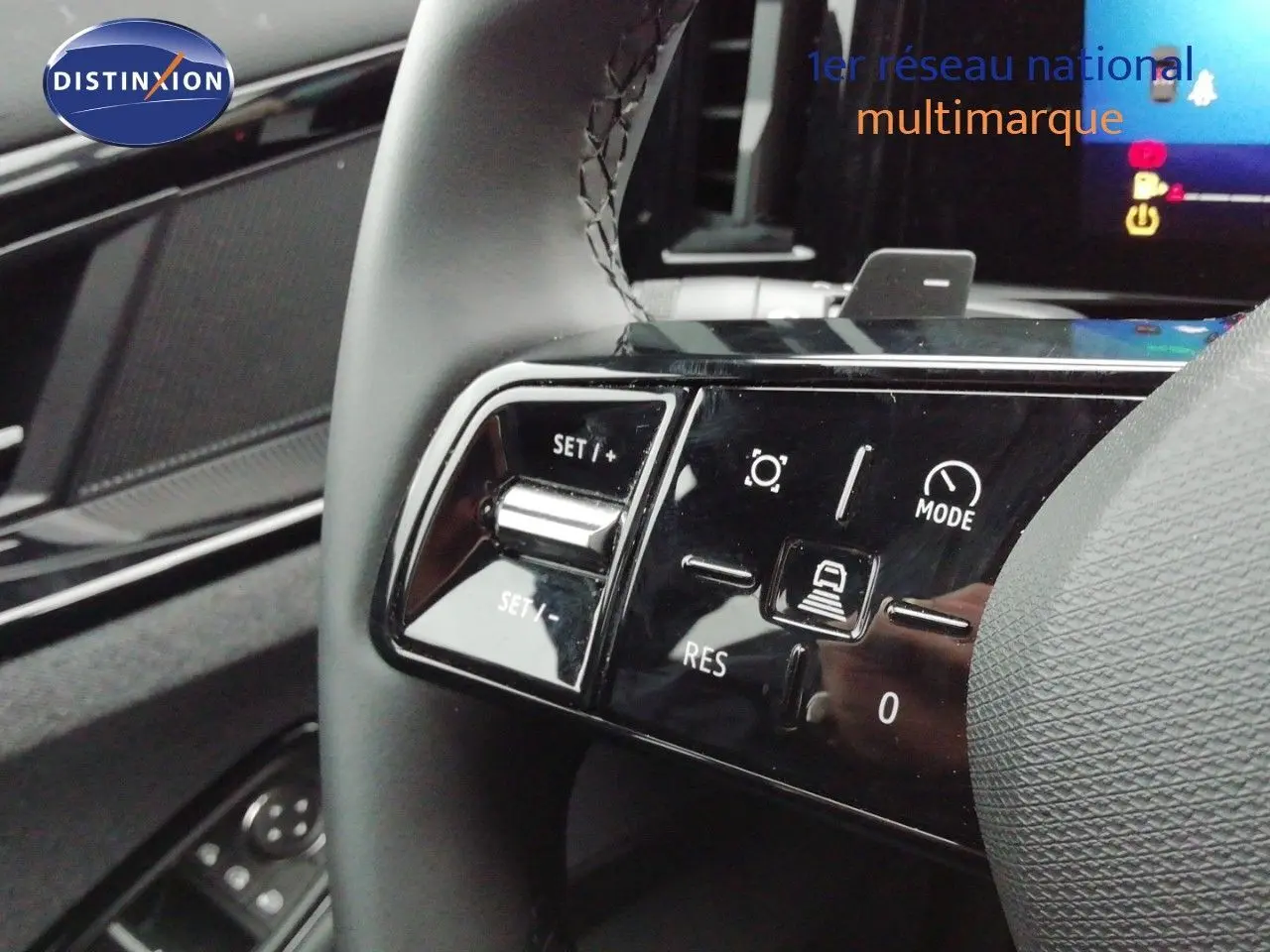 Gros plan sur les commandes du volant du Renault Austral gris schiste, mettant en valeur les boutons de régulateur et mode de conduite.