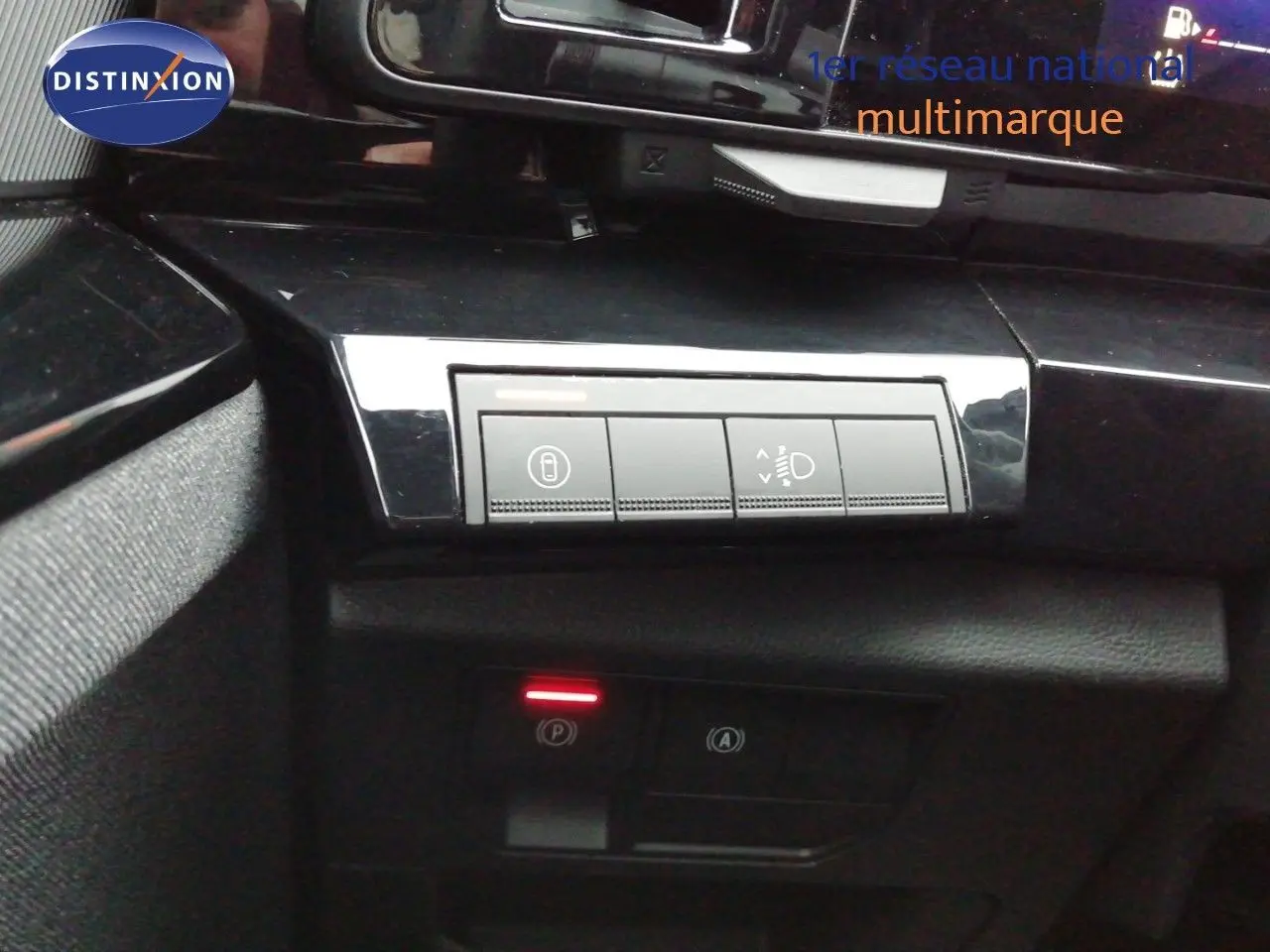 Vue intérieure en gros plan sur les commandes de réglage des phares et frein de parking du Renault Austral gris schiste 2025.