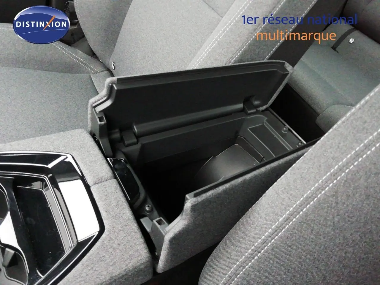 Vue rapprochée de la console centrale ouverte du Renault Austral gris schiste, montrant le rangement intérieur et tissu gris clair.