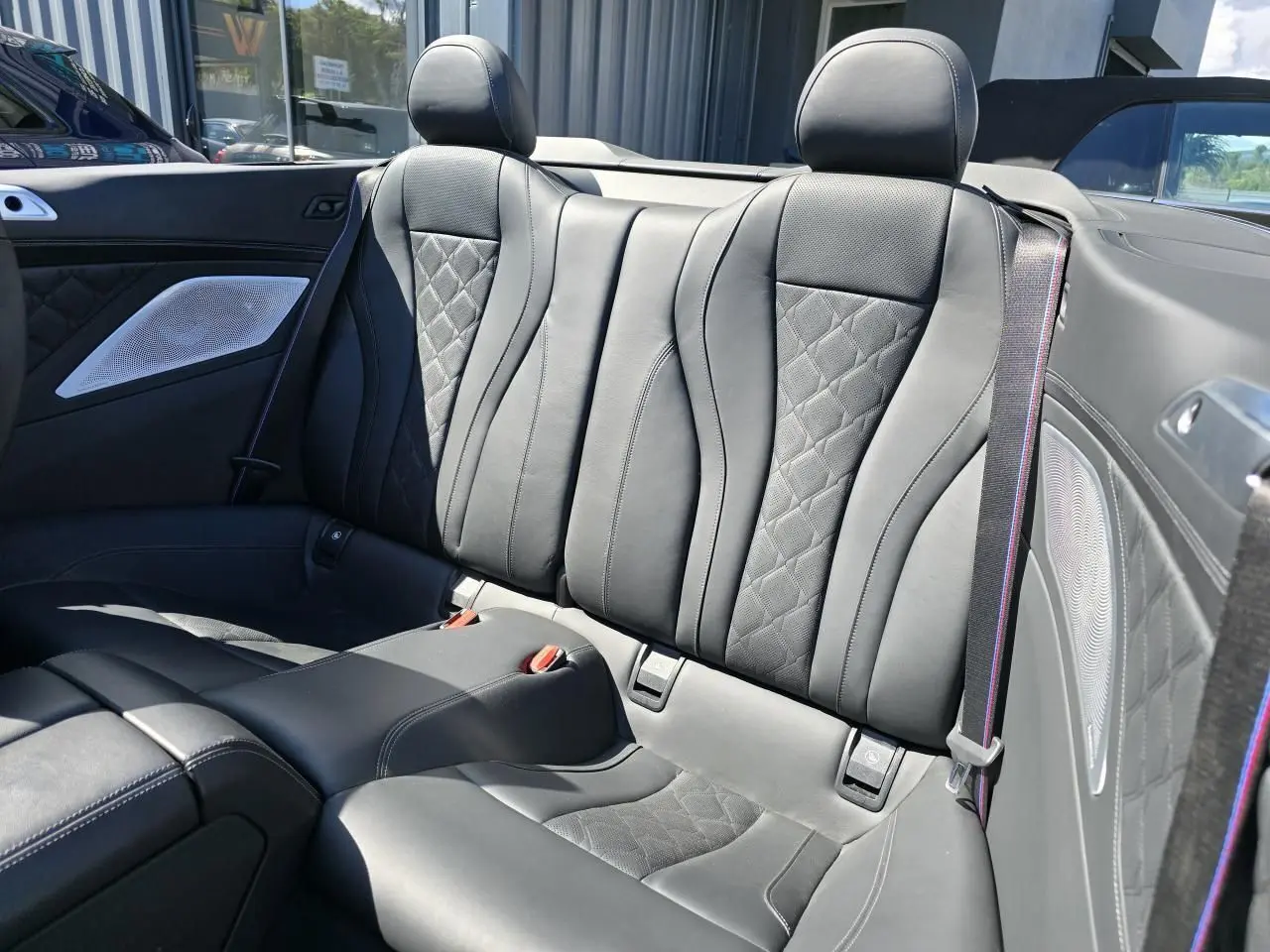Vue rapprochée des sièges arrière en cuir noir avec surpiqûres losanges du cabriolet BMW Série 8 M8 Competition 2021.