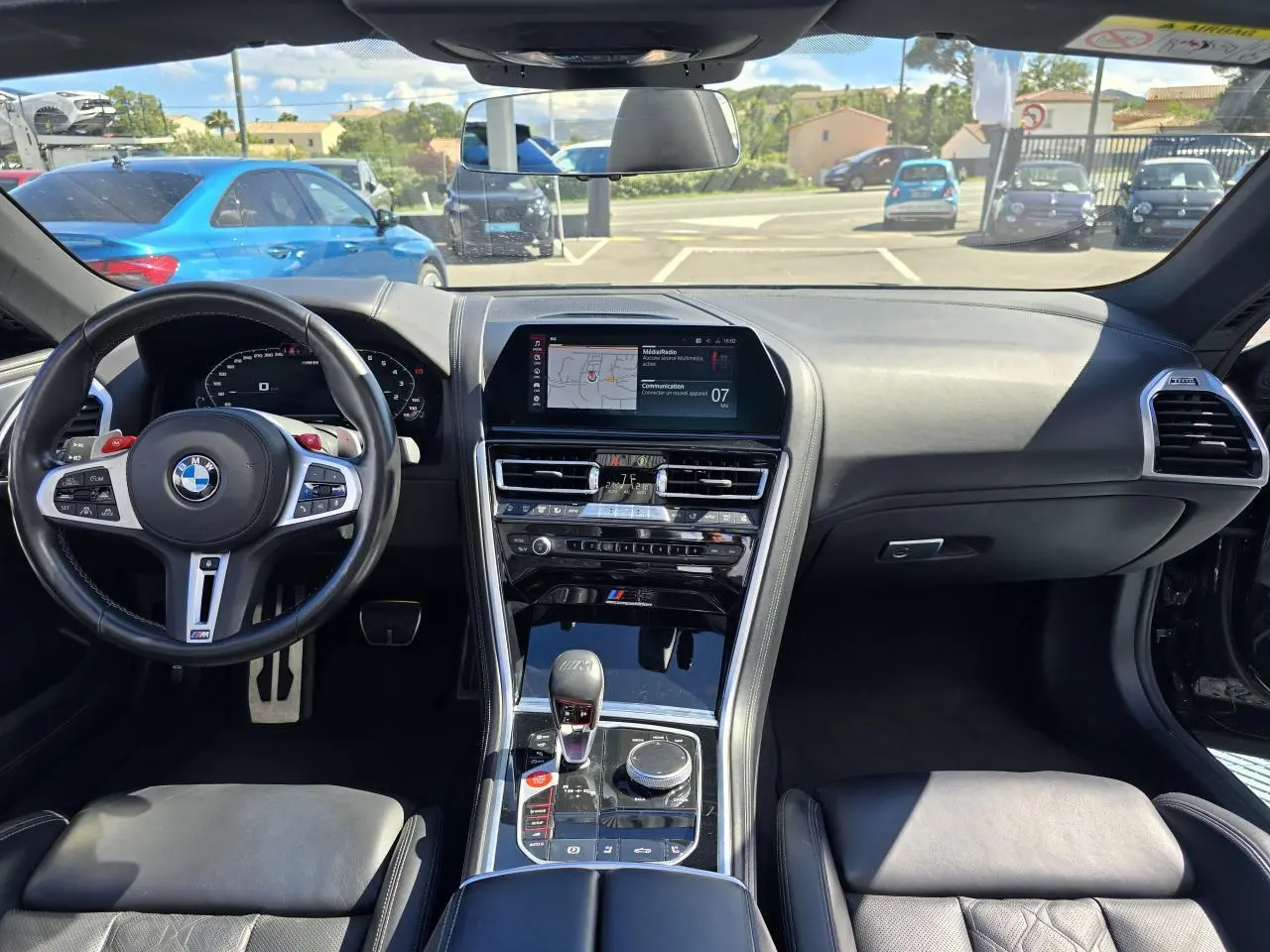 Intérieur noir cuir de la BMW Série 8 Cabriolet M8 Competition 2021, vue frontale sur tableau de bord et volant M sport.