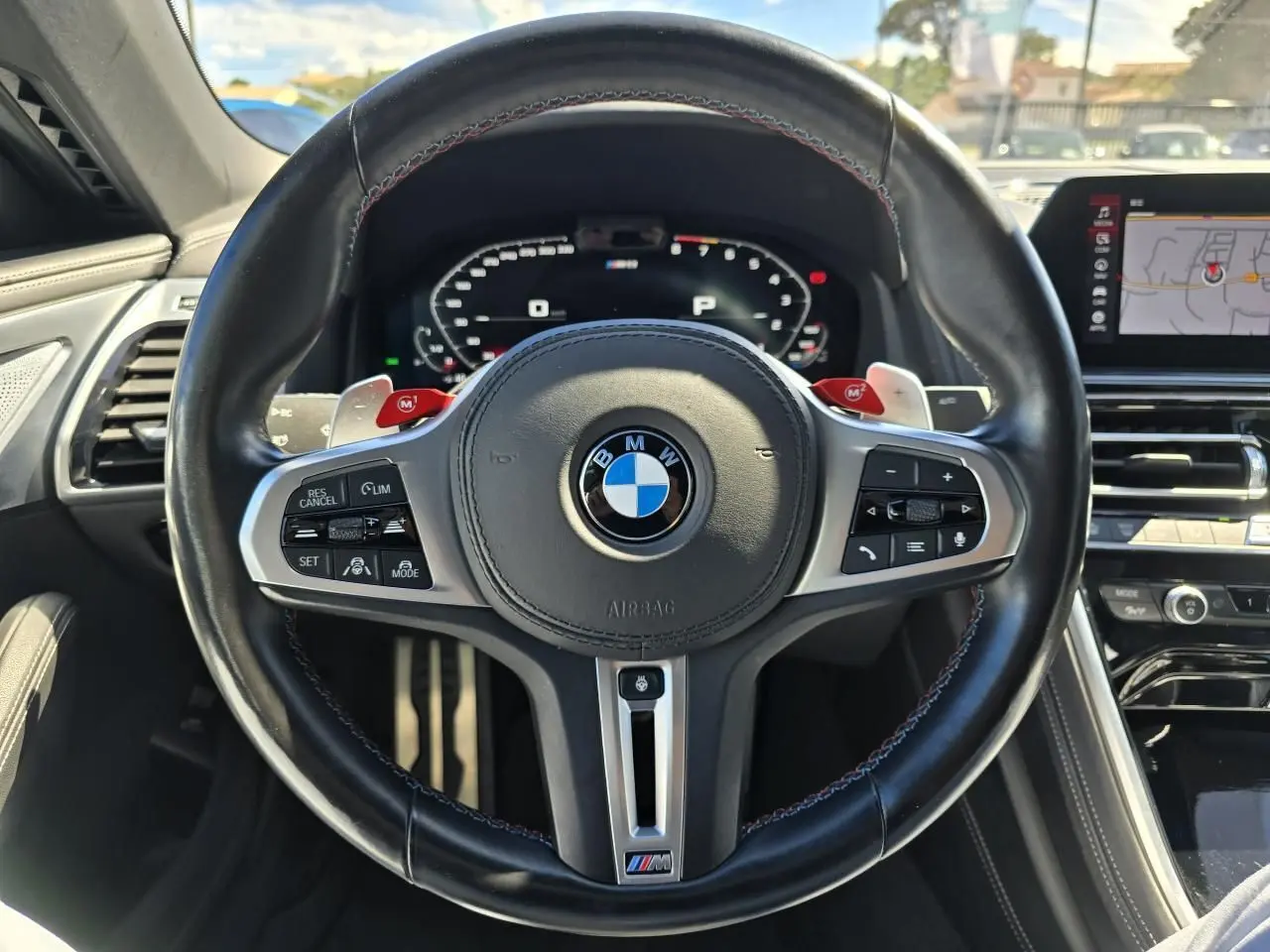 Volant noir en cuir avec logo BMW M, affichage numérique et tableau de bord du BMW Série 8 Cabriolet M8 Competition 2021.