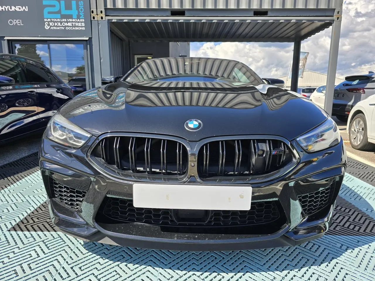 Vue frontale d'une BMW Série 8 Cabriolet M8 Competition noire avec calandre noire brillante et phares LED.