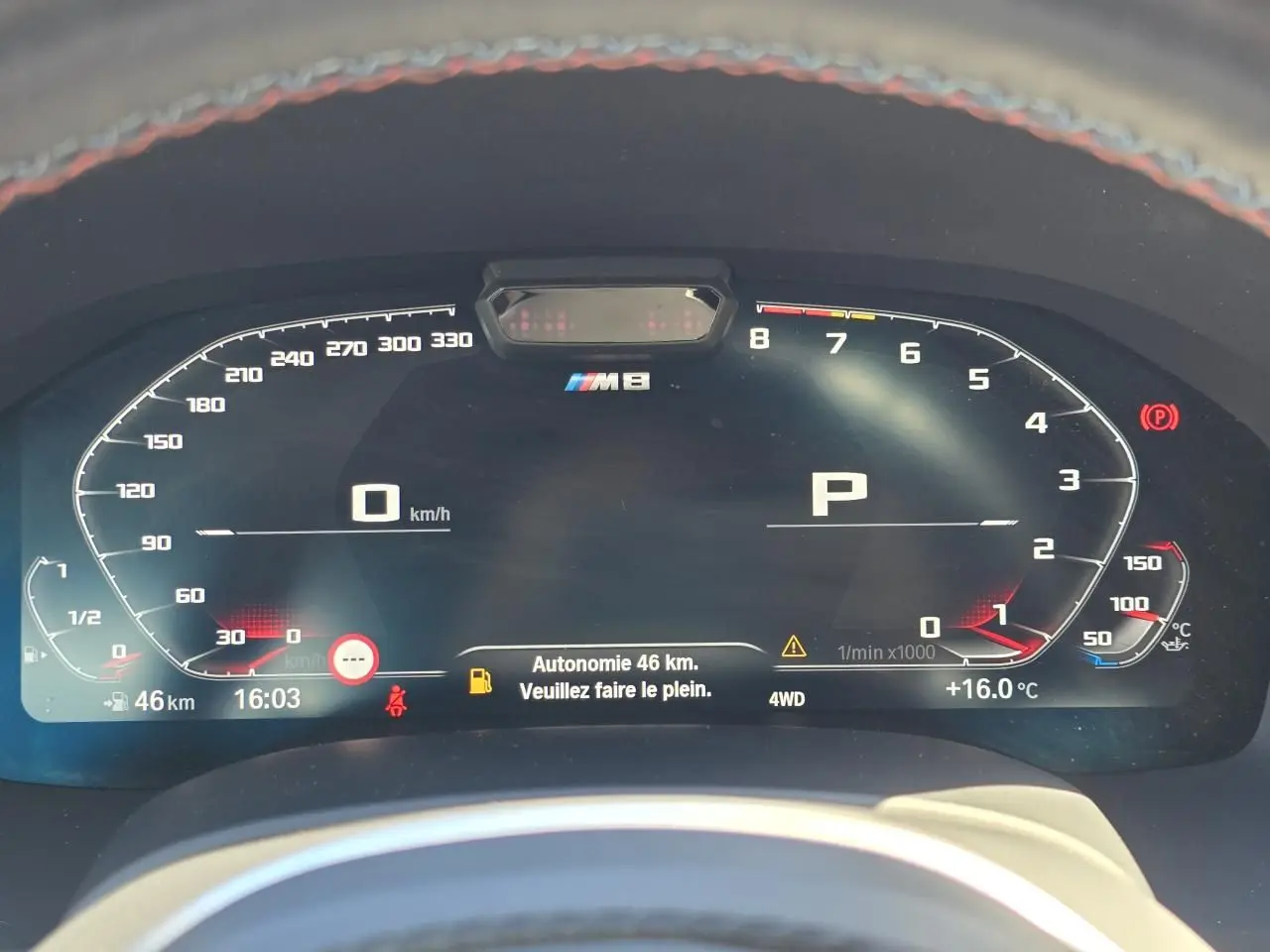 Tableau de bord numérique BMW M8 Competition affichant vitesse, régime moteur et autonomie restante de 46 km.