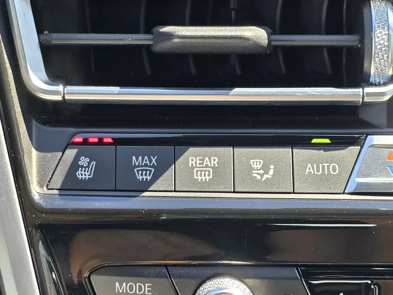 Gros plan sur les commandes de climatisation et sièges chauffants de la BMW Série 8 Cabriolet M8 Competition noir saphir métal.