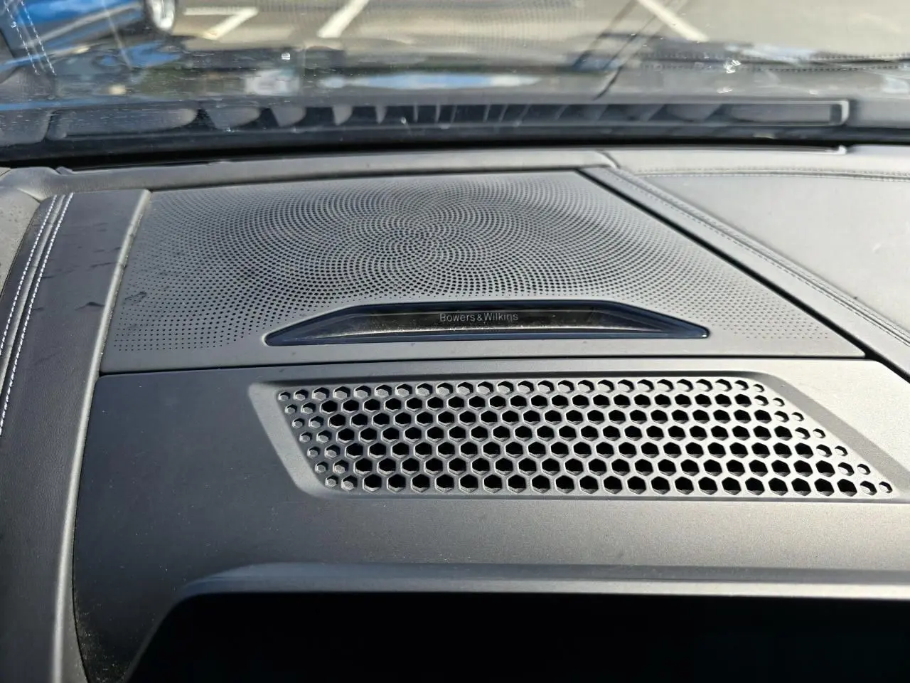 Gros plan sur la grille d'enceinte Bowers & Wilkins intégrée au tableau de bord noir du BMW Série 8 Cabriolet M8 Competition.