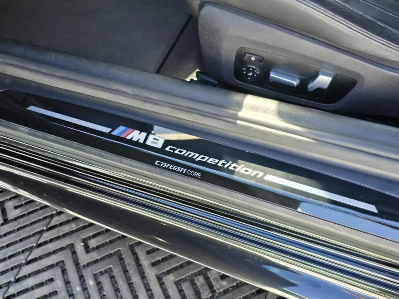 Seuil de porte côté gauche noir brillant avec inscription M8 Competition sur BMW Série 8 Cabriolet noir.