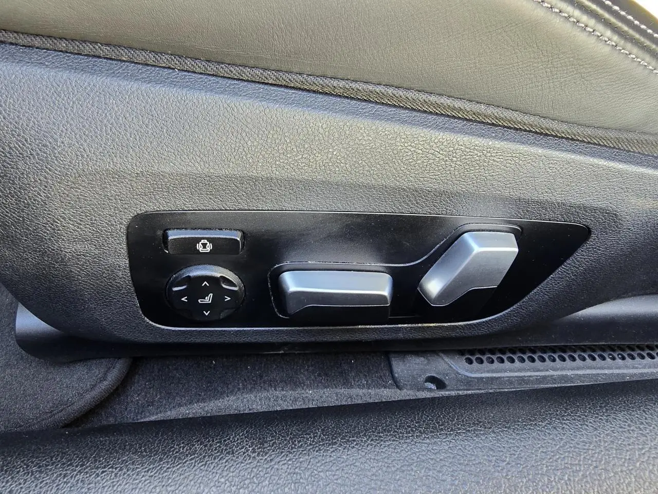 Commandes électriques de réglage du siège en cuir noir dans une BMW Série 8 Cabriolet M8 Competition 2021.