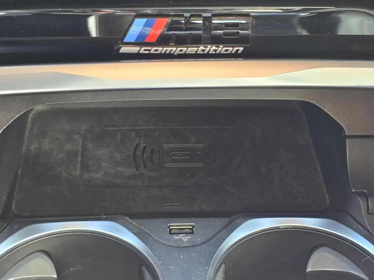 Détail de la console centrale du BMW Série 8 Cabriolet M8 Competition 2021 avec badge M8 et zone de recharge sans fil.