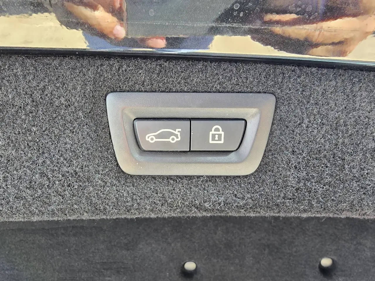 Gros plan sur les boutons d'ouverture et de verrouillage du coffre, intérieur noir en tissu du BMW Série 8 Cabriolet M8 Competition.