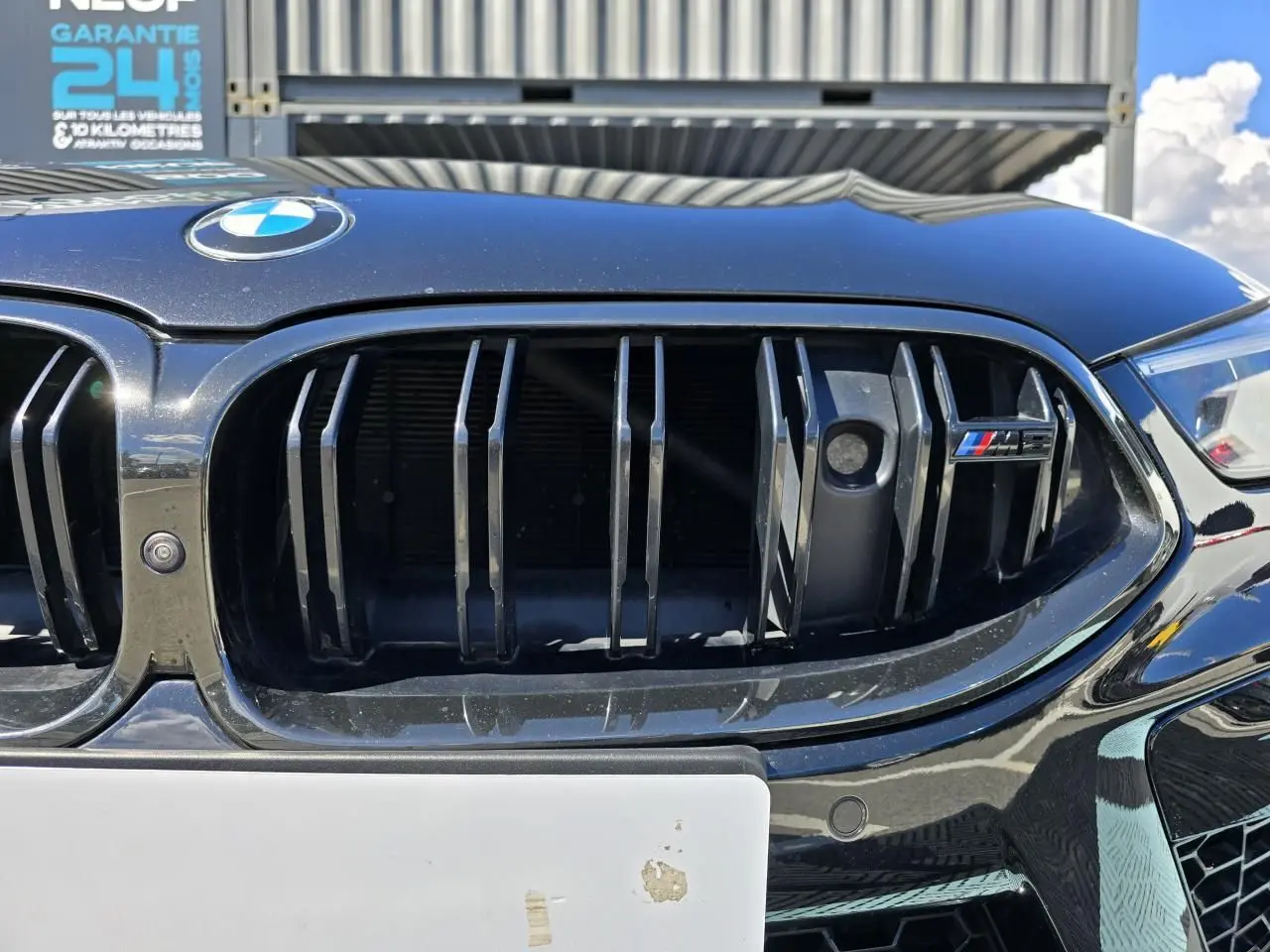 Gros plan sur la calandre noire brillante d'une BMW Série 8 Cabriolet M8 Competition 2021 avec logo M8 coloré.