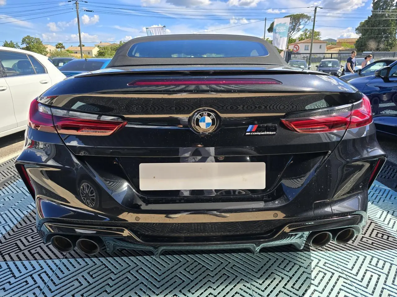 Vue arrière d'un cabriolet BMW Série 8 M8 Competition noir saphir métal avec double sortie d'échappement et logo M8.