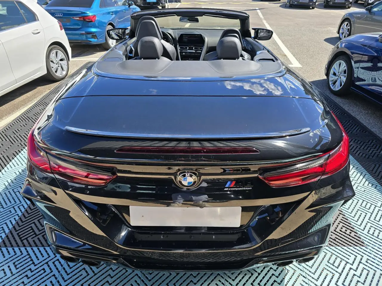 Vue arrière d'une BMW Série 8 Cabriolet M8 Competition noire avec capote ouverte et feux LED distinctifs.