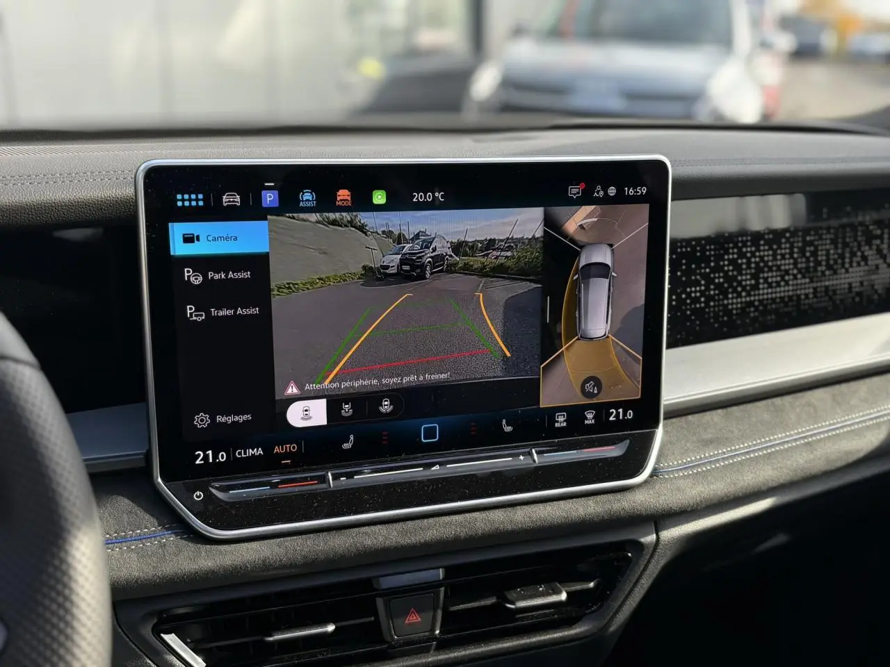 Écran tactile intérieur du Volkswagen Tayron gris dauphin montrant la vue caméra 360° et l'assistance au stationnement.
