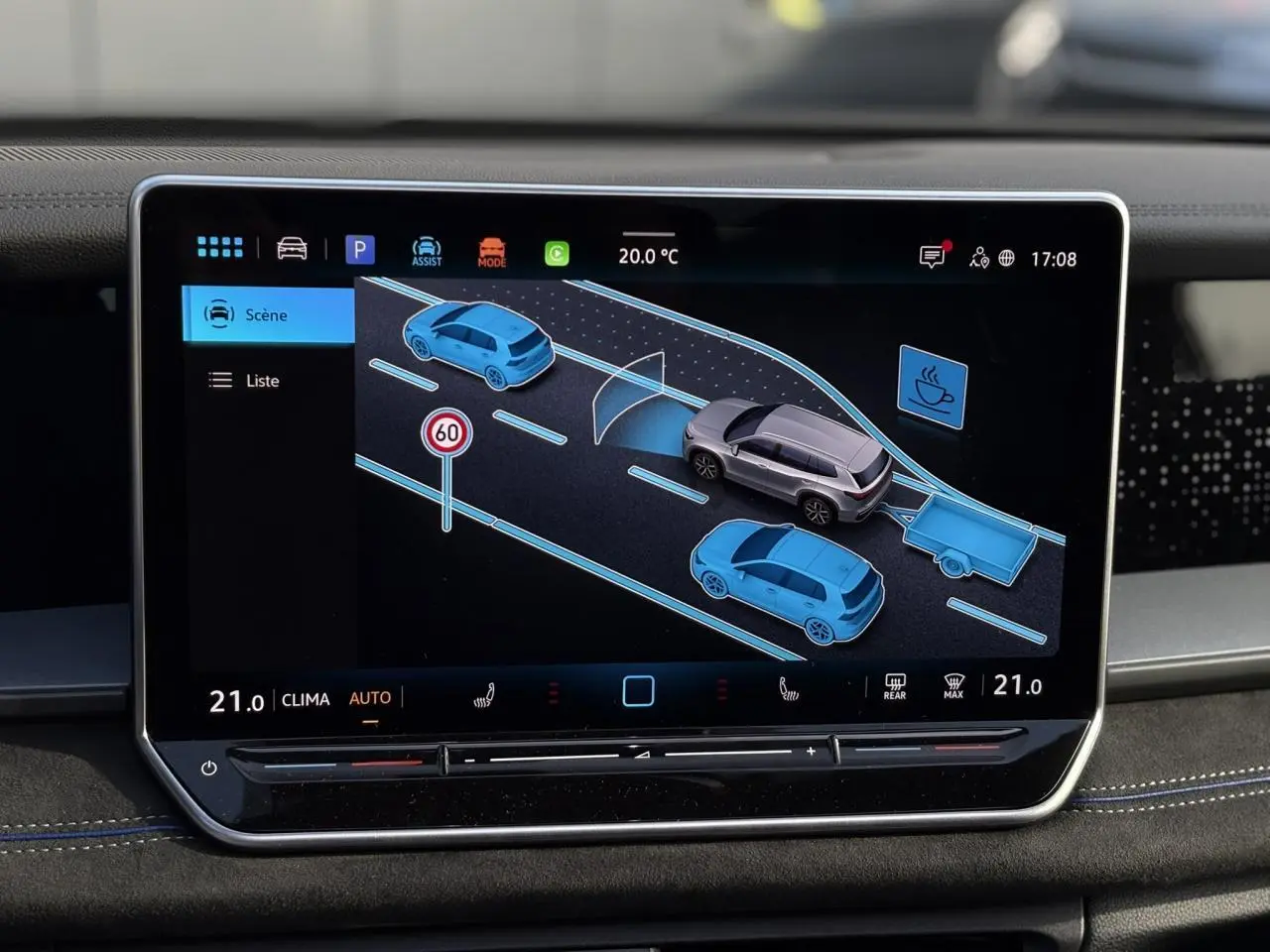 Écran tactile intérieur montrant l'assistance au stationnement avec vue 3D du Volkswagen Tayron gris dauphin et son attelage.