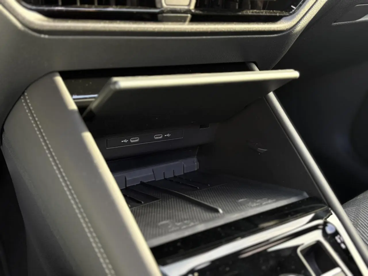Rangement ouvert avec ports USB-C dans l'habitacle noir du Volkswagen Tayron 2.0 TDI R-Line 2025.