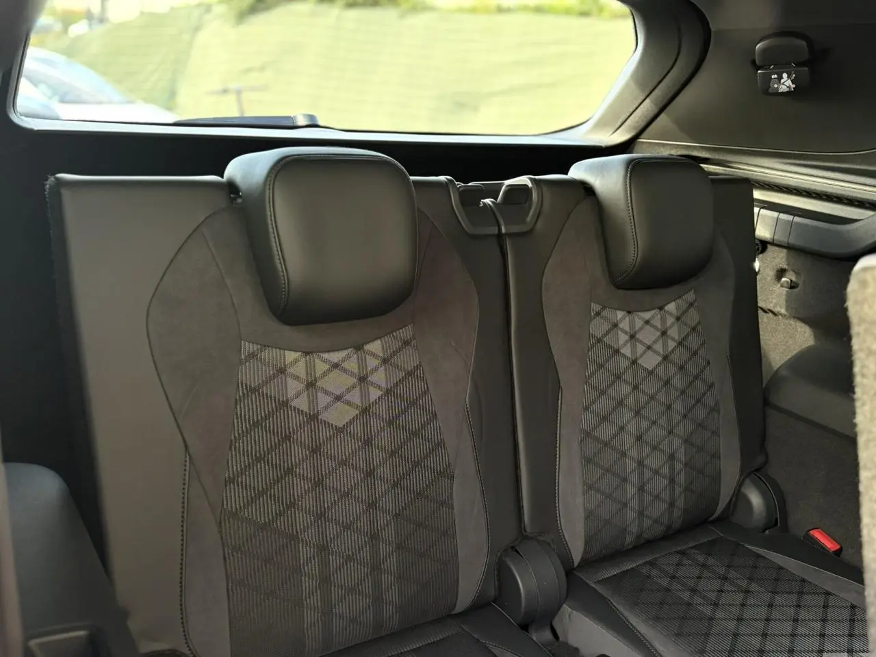 Vue intérieure sur la troisième rangée de sièges en cuir noir et tissu gris du Volkswagen Tayron 2025.