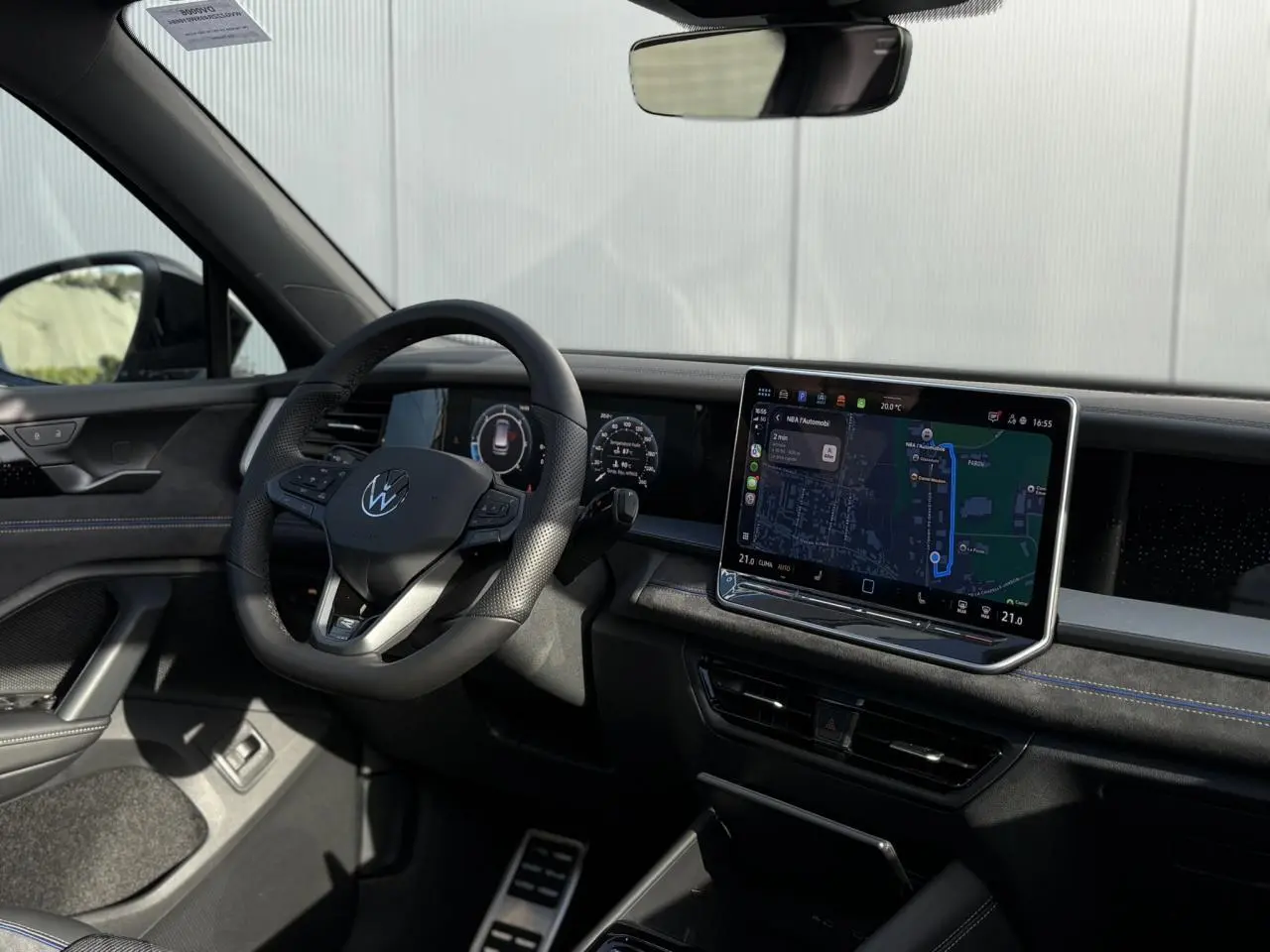 Vue intérieure côté conducteur du Volkswagen Tayron 2025, tableau de bord noir avec écran tactile et volant multifonction.