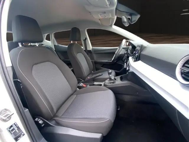 Intérieur de la SEAT IBIZA 1.0 MPI 80 STYLE 2023 en blanc candy, vue côté gauche sur les sièges avant et le tableau de bord moderne.