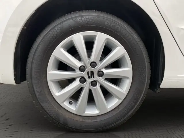 Gros plan sur la roue avant droite blanche d'une SEAT IBIZA 1.0 MPI 80 STYLE 2023 avec jante alliage argentée.