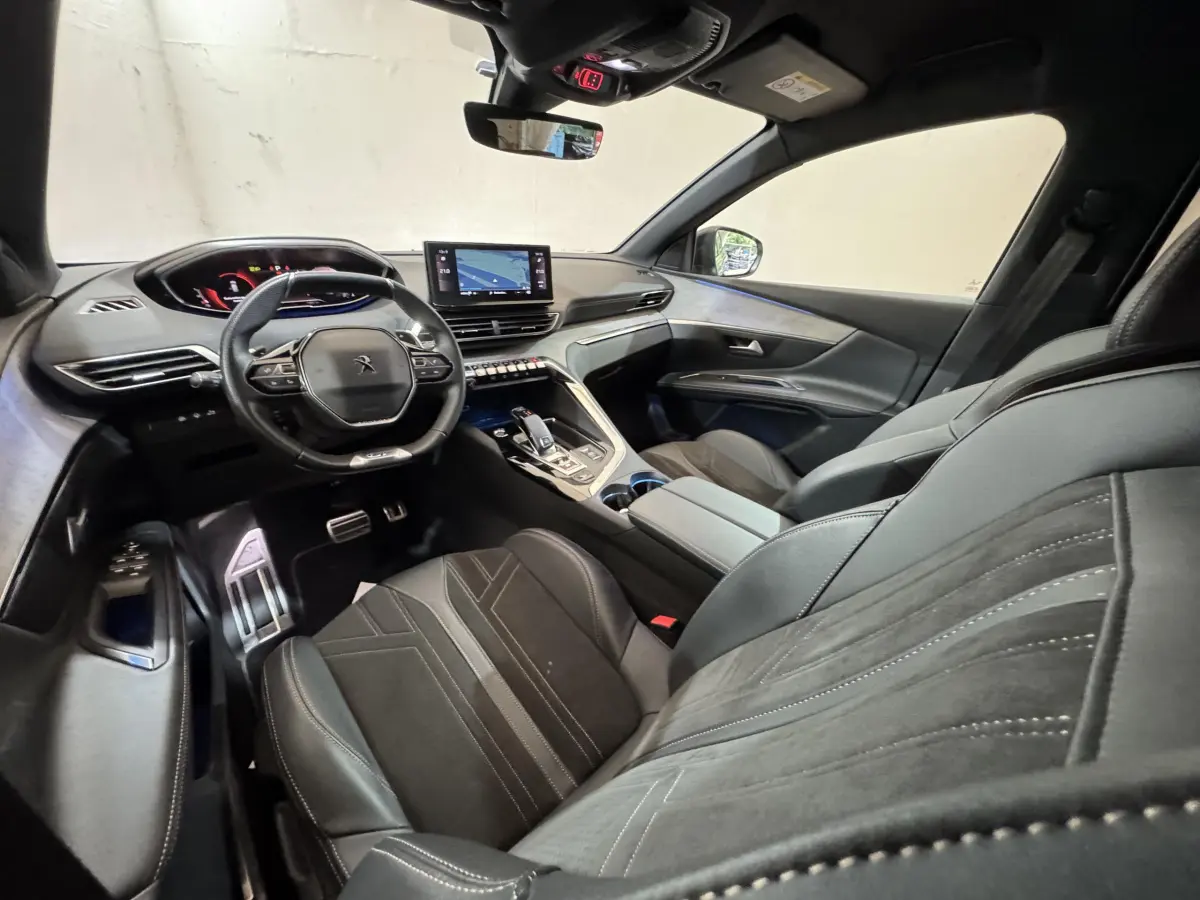 Intérieur du Peugeot 3008 gris clair, vue côté conducteur, volant cuir multifonctions et écran tactile central visible.