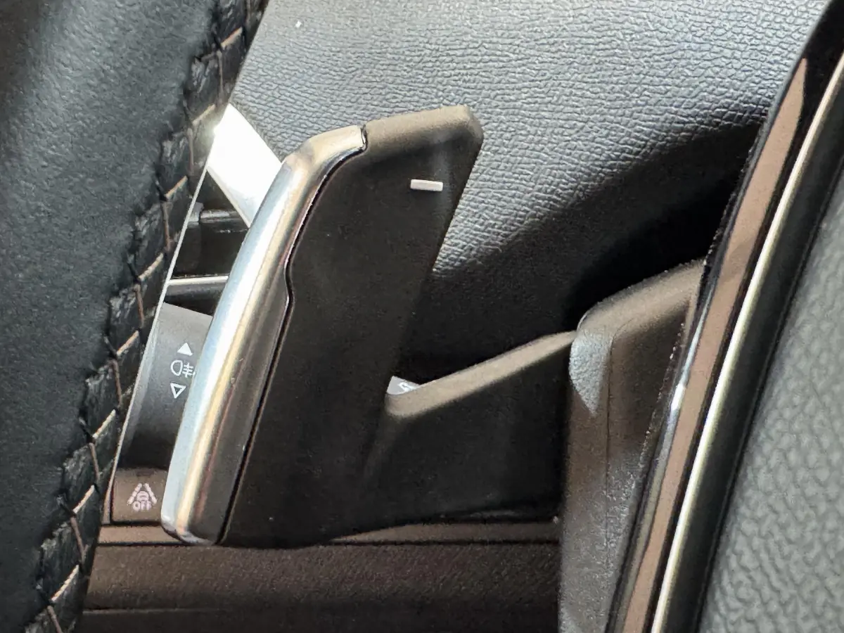 Gros plan sur la palette de changement de vitesse noire et argentée du volant du Peugeot 3008 GT gris clair.