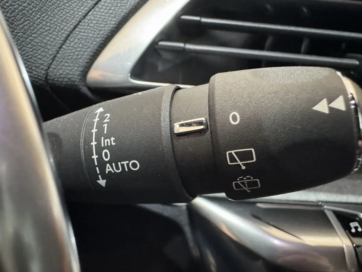 Gros plan sur la commande des essuie-glaces dans l'habitacle noir du Peugeot 3008 gris clair de 2021