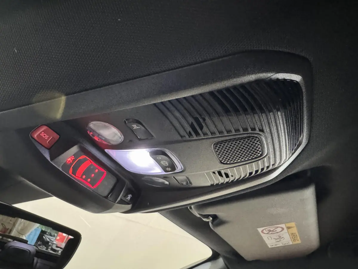Plafonnier intérieur avec commandes lumineuses et bouton SOS du Peugeot 3008 GT gris clair, vue en contre-plongée.