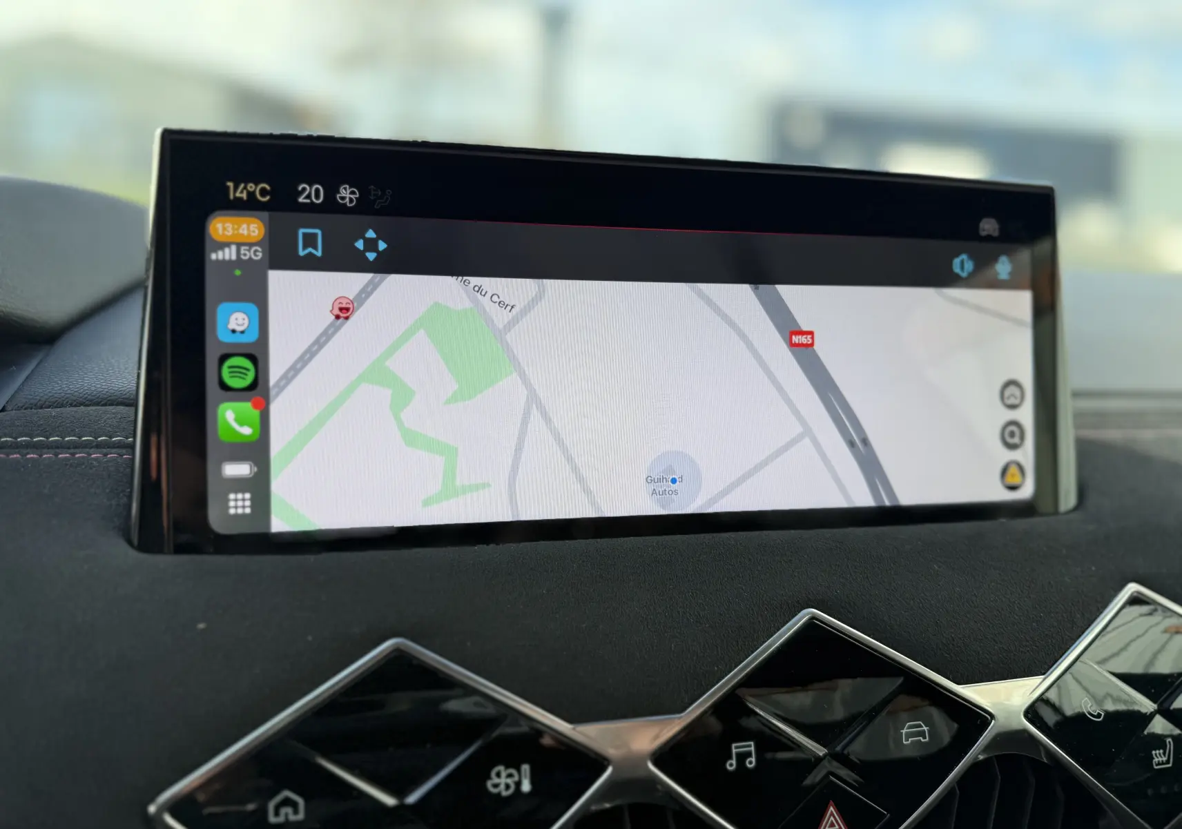 Écran tactile central affichant la navigation dans l’habitacle du DS3 Hybride 2025 avec finition noire et surpiqûres rouges.