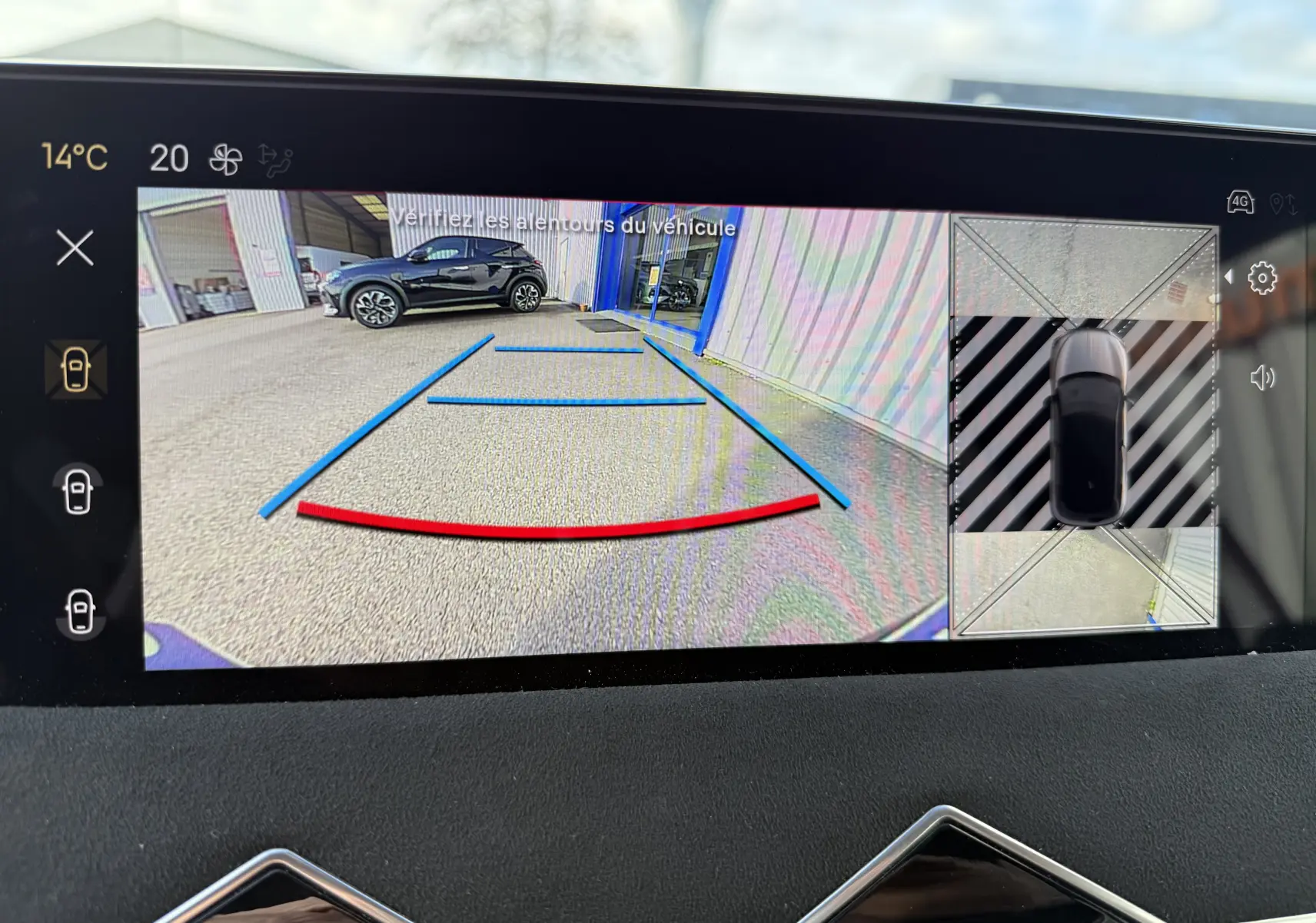 Vue écran caméra de recul du DS3 hybride gris Artense toit noir, avec lignes de guidage bleues et rouges visibles.