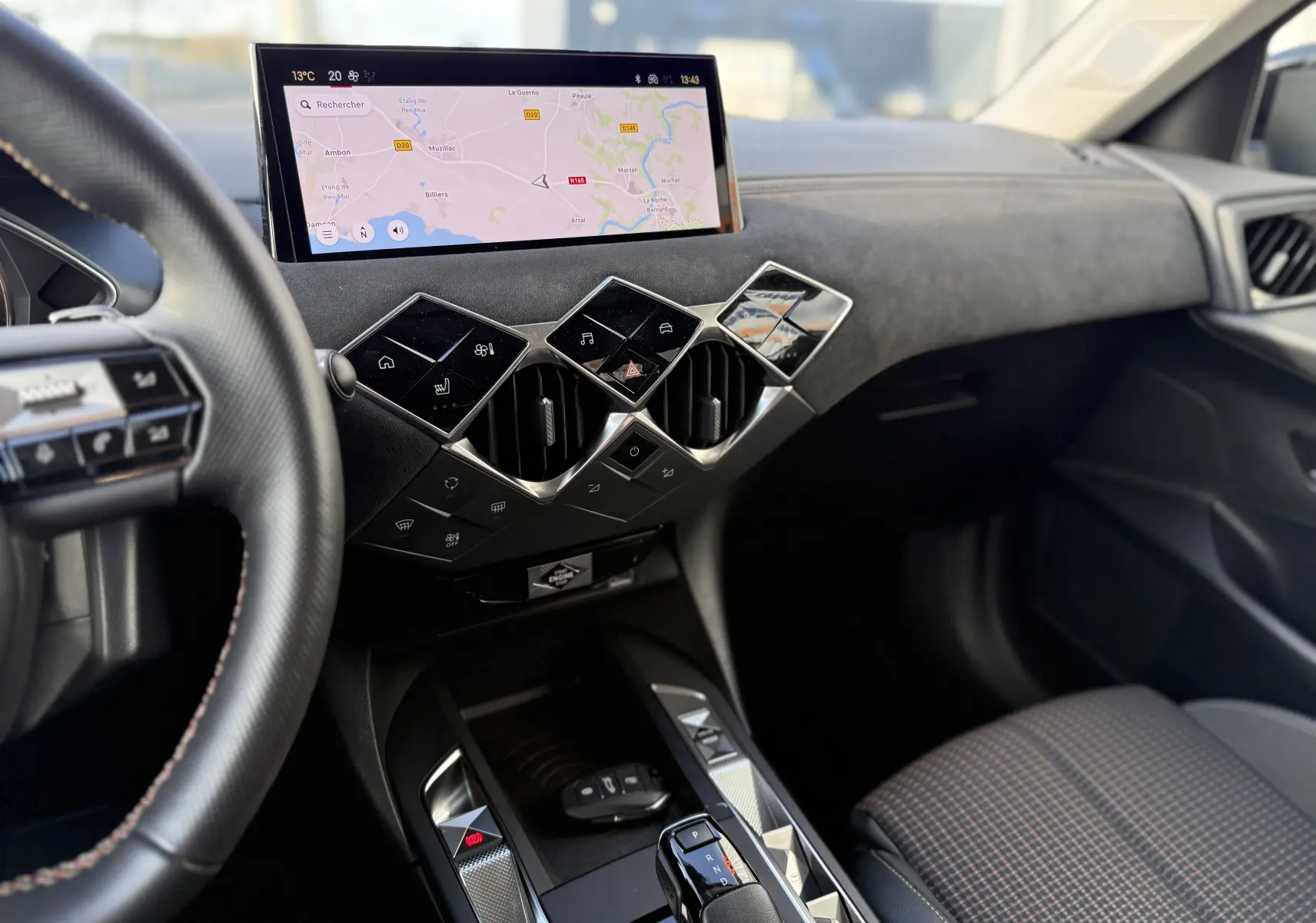 Vue intérieure côté conducteur du tableau de bord et console centrale du DS3 Hybride 2025, avec écran tactile et commandes géométriques.