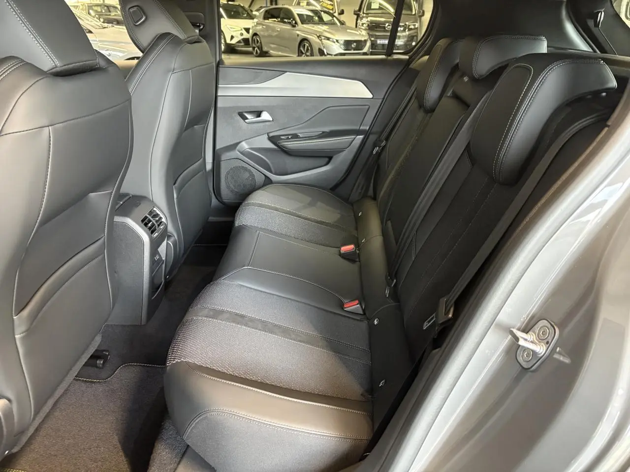 Vue intérieure côté droit des sièges arrière noirs en tissu et cuir dans une Peugeot 308 gris selenium 2025.
