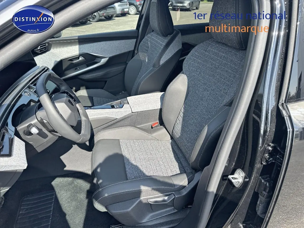 Vue intérieure côté conducteur du Peugeot 3008 noir perla nera, sièges tissu et cuir avec accoudoir central.