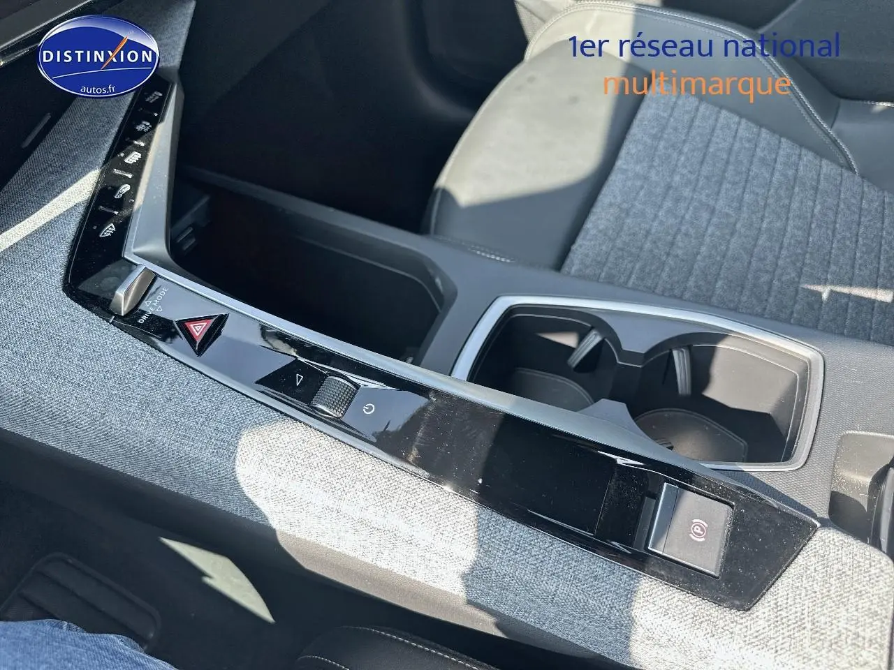 Gros plan sur la console centrale du Peugeot 3008 noir perla nera, avec accoudoir et porte-gobelets visibles.
