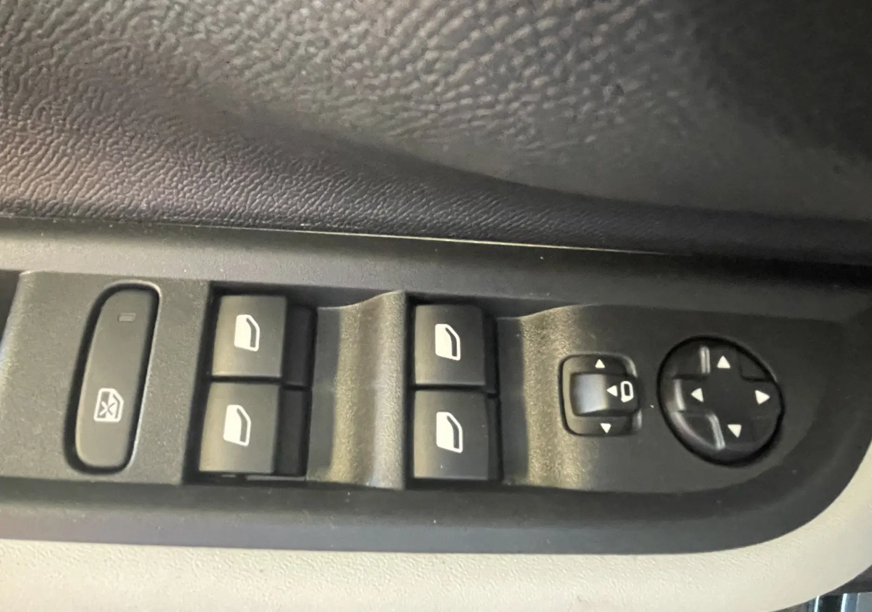 Commande des vitres électriques et réglage des rétroviseurs côté conducteur d'une Citroën C3 E-C3 113 MAX noire.