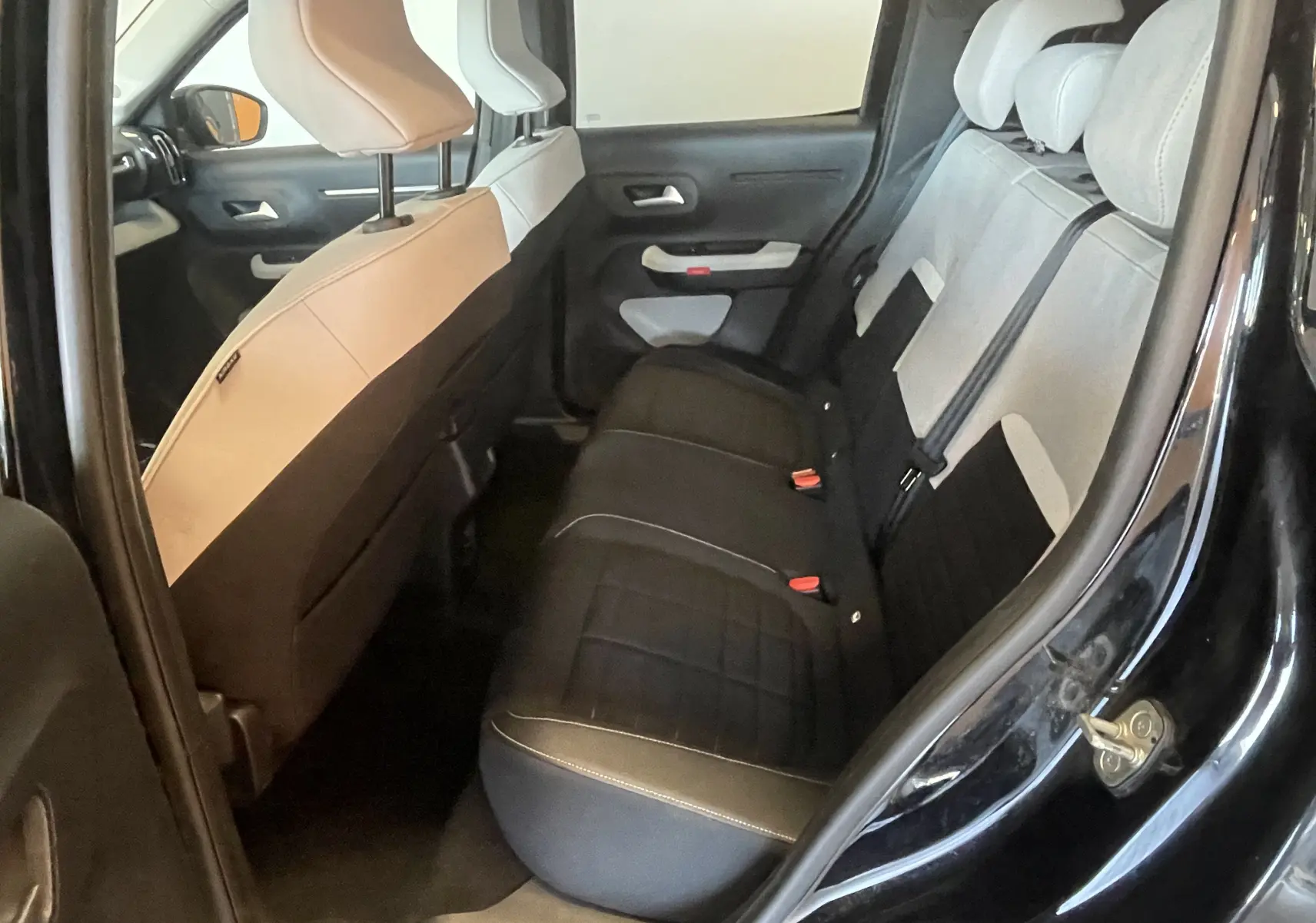 Vue intérieure arrière côté droit d'une Citroën E-C3 113 MAX 2025 noire, avec sellerie tissu noir et claire bicolore.
