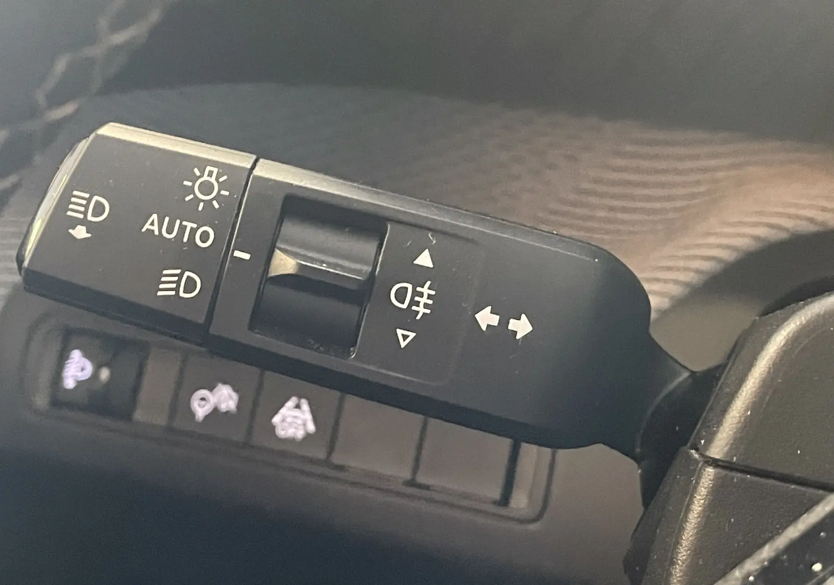 Gros plan sur la commande des feux et clignotants à gauche du volant dans une Citroën C3 E-C3 113 MAX noire 2025.