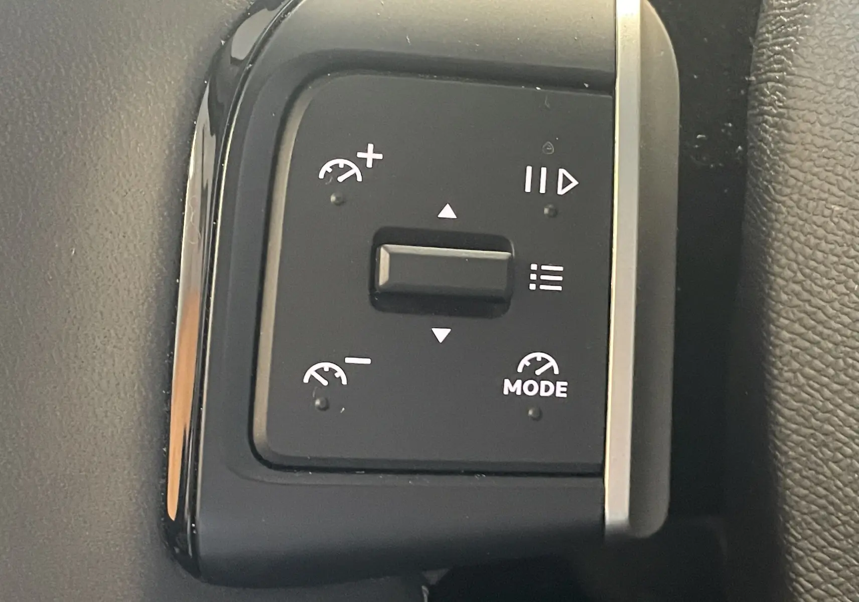 Gros plan sur les commandes de régulateur de vitesse au volant du Citroën E-C3 113 MAX noir, intérieur 2025.