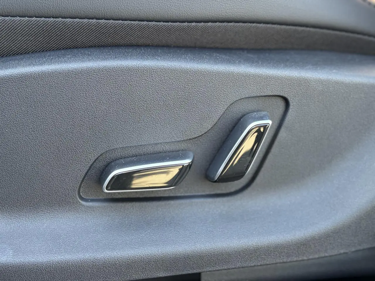 Gros plan sur les commandes électriques des sièges noirs à l'intérieur du BYD SEAL U 2025 couleur Boundless Cloud.