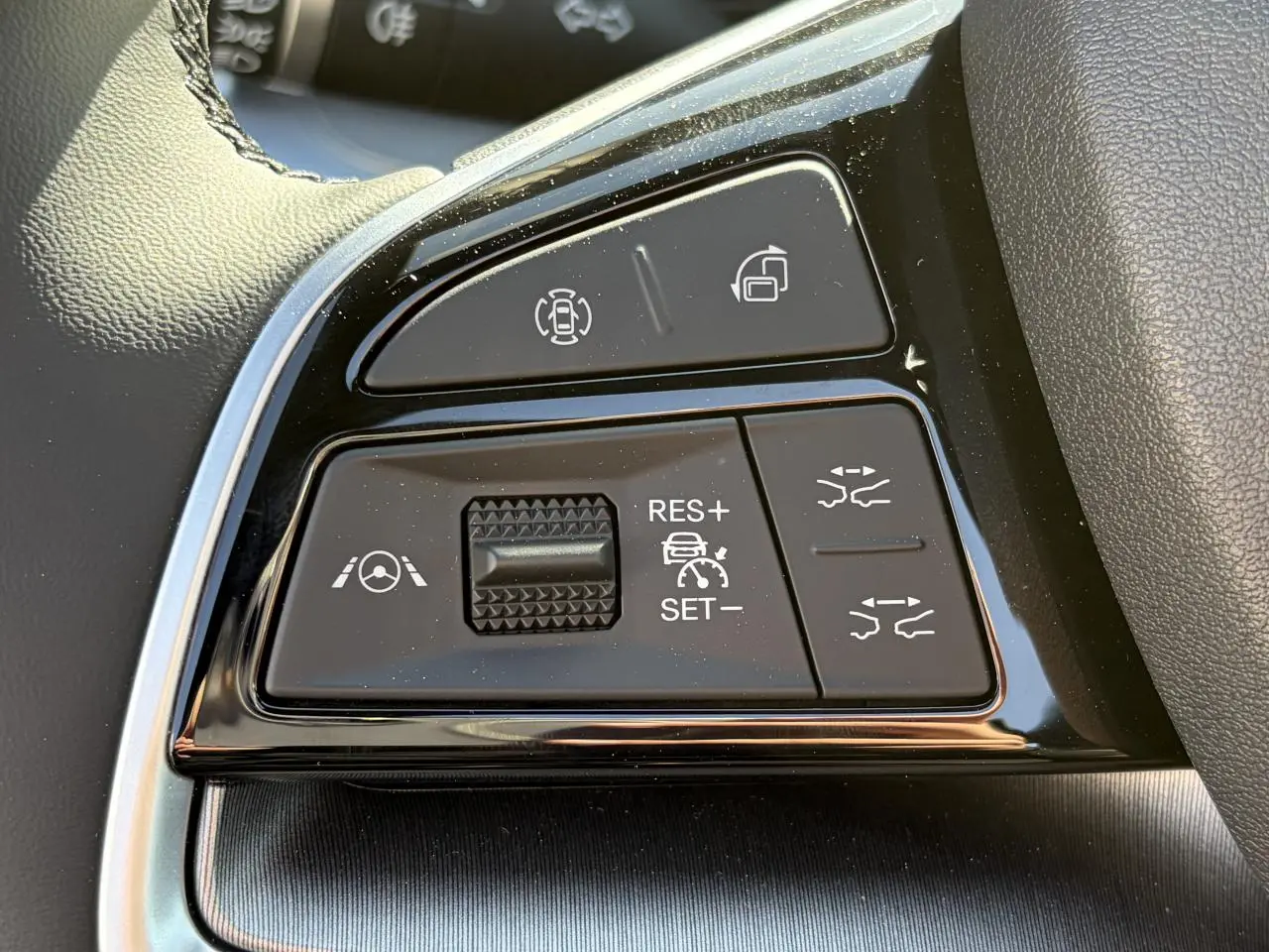 Gros plan sur les commandes du volant noir du BYD SEAL U 2025, avec boutons de régulateur de vitesse et aides à la conduite.