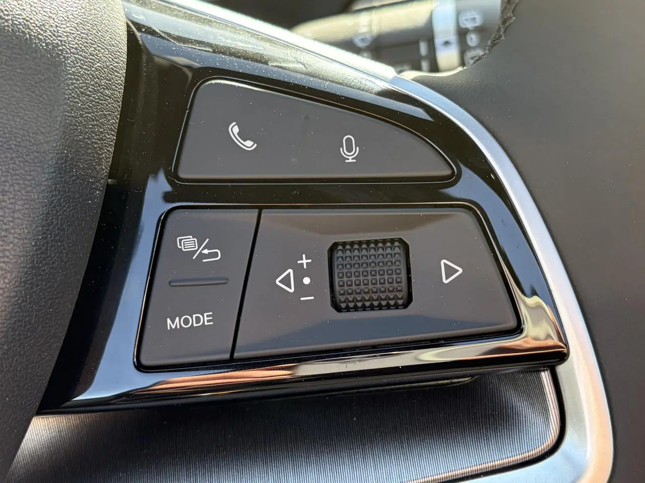 Gros plan sur les commandes multifonctions noires du volant du BYD SEAL U 2025 avec finition brillante.