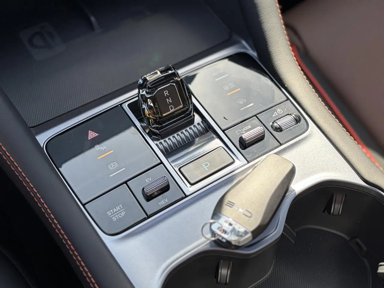 Vue rapprochée de la console centrale du BYD SEAL U 2025, avec levier de vitesses cristal et clé posée, finition noire et brun.